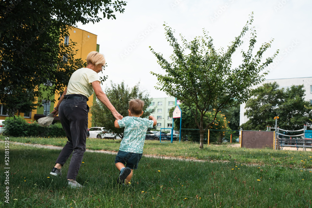 Grandmother and child running in kindergarten. Happy family idea. Generation, happiness vitality concept Grandmother and child running in kindergarten. Happy family idea. Generation, happiness vitality concept