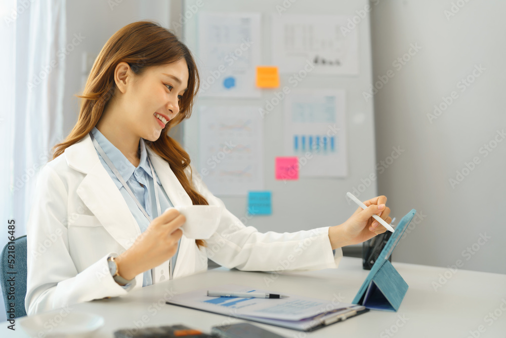 Successful business concept, Businesswoman drinking coffee and taking notes data on tablet Successful business concept, Businesswoman drinking coffee and taking notes data on tablet