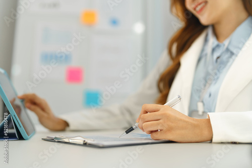 Successful business concept, Businesswoman reading financial report on tablet and taking note data © Pichsakul
