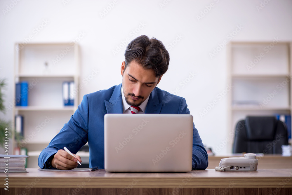 Young male employee working in the office Young male employee working in the office