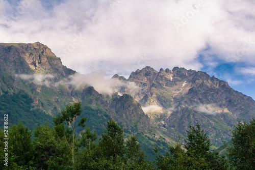 View of huge mountains with waterfalls and beautiful clouds in North Ossetia.