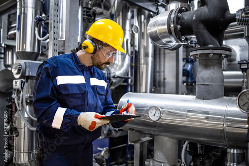 Refinery worker checking pipes pressure and natural gas supply in production plant.