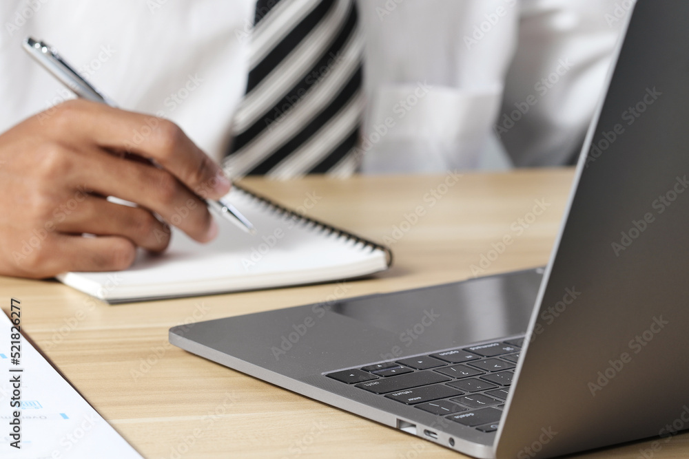 Businessman analyzing business plan documents and laptop computer on desk. Work planning concept Businessman analyzing business plan documents and laptop computer on desk. Work planning concept