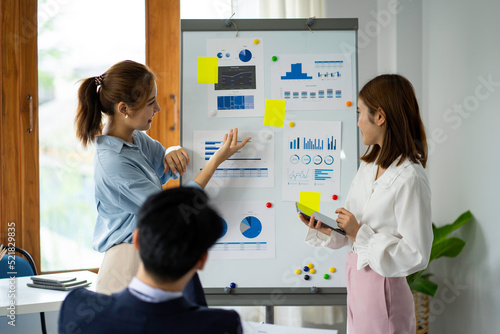 group of professional Asian businessmen use paper on the board. Writing a business plan strategy for growth and success Happy Asian woman working at the office