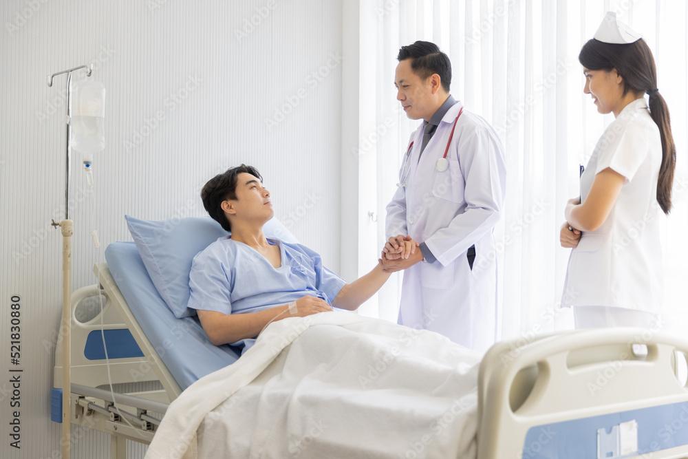 Professional male doctor and nurse caring visiting encourage male patient at hospital Professional male doctor and nurse caring visiting encourage male patient at hospital