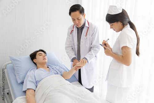 Professional doctor and nurse visiting checking recover male patient at hospital