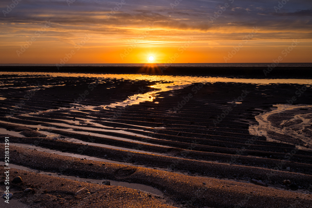 Colorful sunset on the Atlantic coast at low tide in Normandy, France