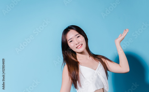 Charming asian beauty woman hold sun cream with sun protection uv or sunscreen on the blue background © Kiattisak