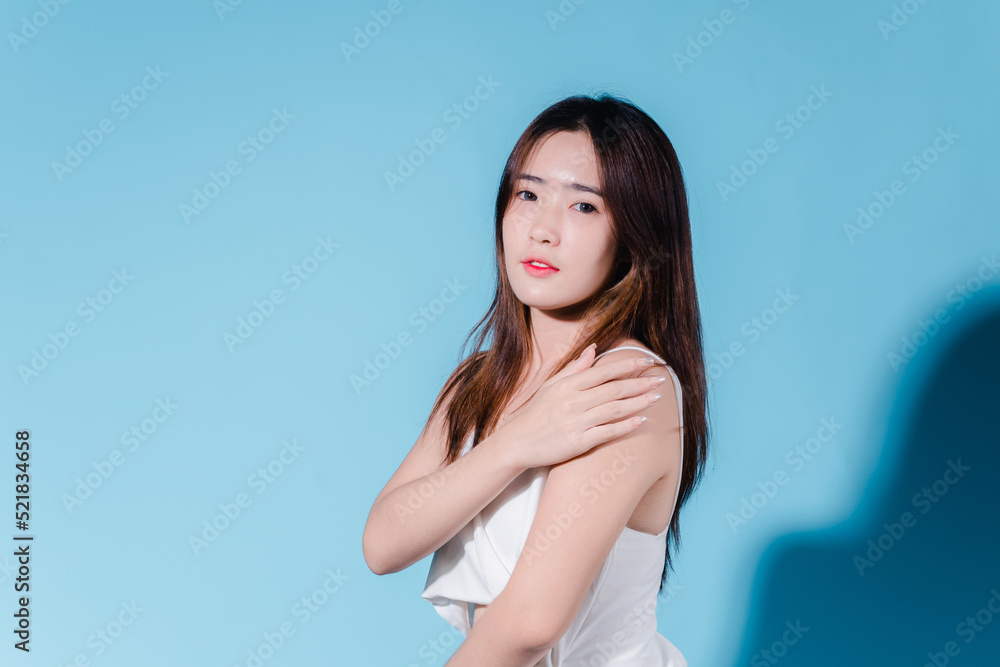 Charming asian beauty woman hold sun cream with sun protection uv or sunscreen on the blue background Charming asian beauty woman hold sun cream with sun protection uv or sunscreen on the blue background