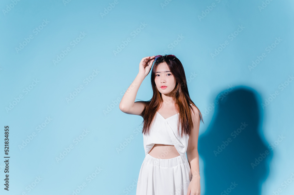 Charming asian beauty woman hold sun cream with sun protection uv or sunscreen on the blue background Charming asian beauty woman hold sun cream with sun protection uv or sunscreen on the blue background