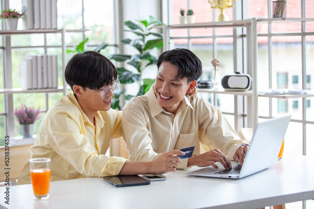 Asian gay couples are using laptop or shopping online with credit card, LGBTQ concept. Asian gay couples are using laptop or shopping online with credit card, LGBTQ concept.