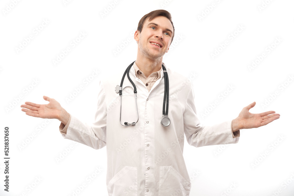 Handsome doctor in white medical coat with stethoscope holding something isolated on white background with copy space. Demonstrates product Handsome doctor in white medical coat with stethoscope holding something isolated on white background with copy space. Demonstrates product