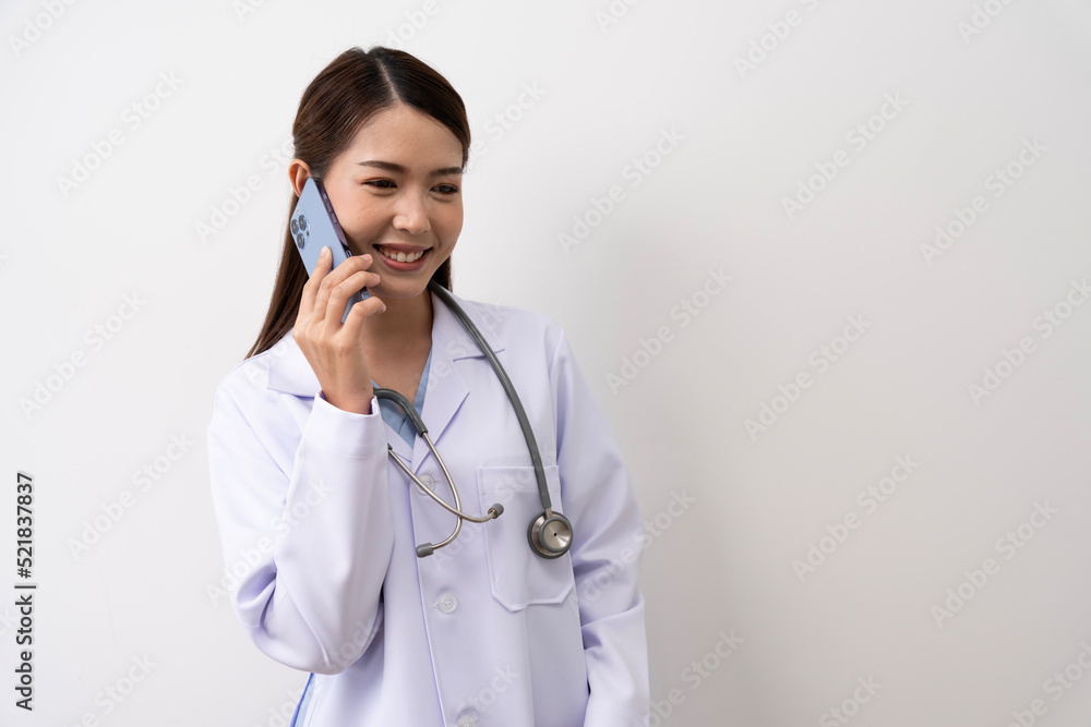 An Asian female doctor in Thailand is communicating with patients over the Internet with her personal phone at the hospital to advise patients at home with confidence isolated background An Asian female doctor in Thailand is communicating with patients over the Internet with her personal phone at the hospital to advise patients at home with confidence isolated background