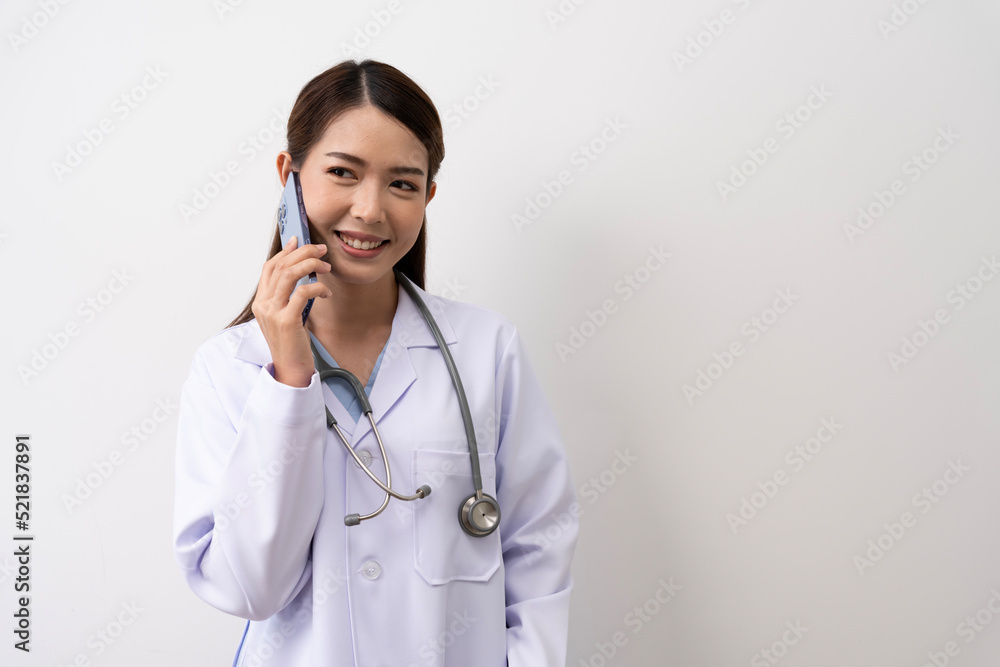 An Asian female doctor in Thailand is communicating with patients over the Internet with her personal phone at the hospital to advise patients at home with confidence isolated background An Asian female doctor in Thailand is communicating with patients over the Internet with her personal phone at the hospital to advise patients at home with confidence isolated background