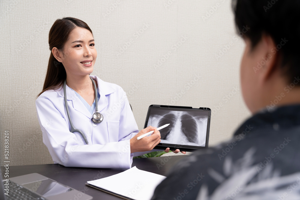 A beautiful Asian doctor discusses the condition of a male patient being hospitalized Check the x-ray results of the lungs in tablet A beautiful Asian doctor discusses the condition of a male patient being hospitalized Check the x-ray results of the lungs in tablet