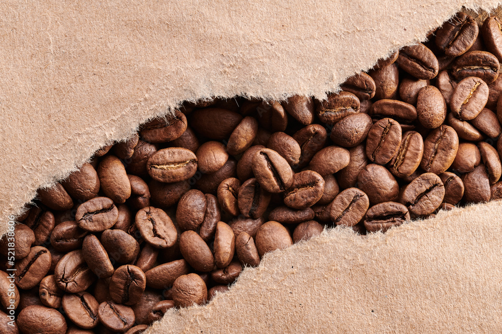 Roasted coffee beans decorated with kraft paper close-up creative background Roasted coffee beans decorated with kraft paper close-up creative background