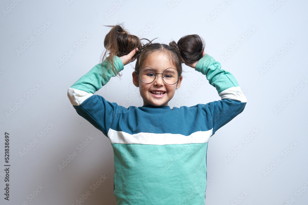 Fototapeta premium Portrait of funny brunette little girl fooling around rejoicing isolated on white background