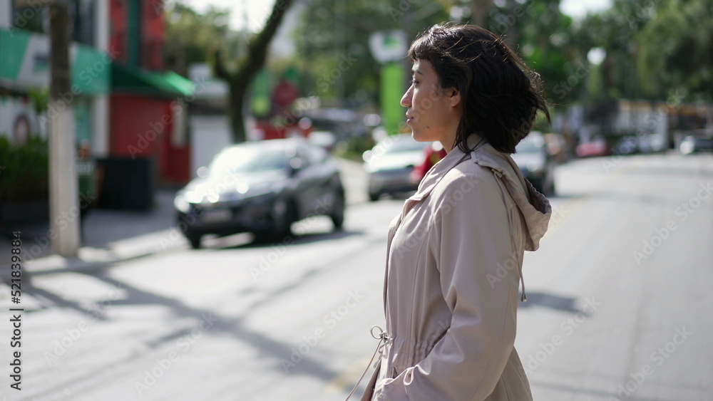 One hispanic woman crossing street. Person crosses crosswalk in urban city One hispanic woman crossing street. Person crosses crosswalk in urban city