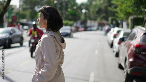 One hispanic woman crossing street. Person crosses crosswalk in urban city © Marco