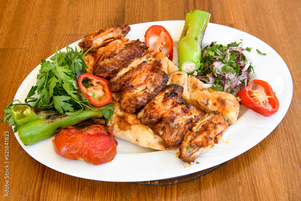 A skewered chicken kebob with grilled onions, bell peppers and delicious white meat with seasoning isolated on a white background. Tavuk sis, Tavuk izgara.