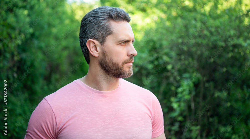 Portrait of handsome unshaven man looking aside natural background outdoors, copy space Portrait of handsome unshaven man looking aside natural background outdoors, copy space