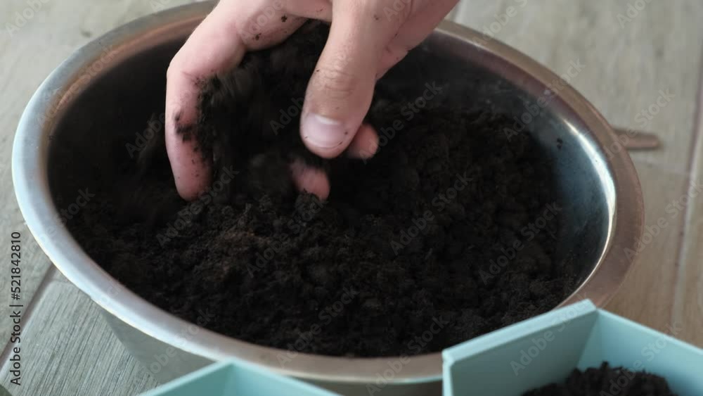 A man checks loose moistened soil for home plants, close-up A man checks loose moistened soil for home plants, close-up