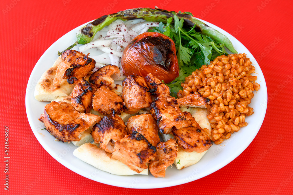 A skewered chicken kebob with grilled onions, bell peppers and delicious white meat with seasoning isolated on a white background. Tavuk sis, Tavuk izgara. A skewered chicken kebob with grilled onions, bell peppers and delicious white meat with seasoning isolated on a white background. Tavuk sis, Tavuk izgara.