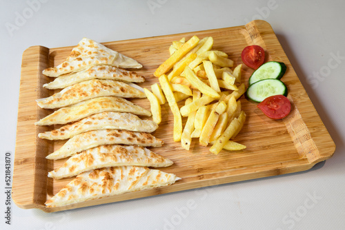 Freshly baked appetizing Turkish tortillas -Gozleme with spinach, cheese  on a wooden board. Shallow depth of  field. Handmade Turkish traditional pastries. Otlu peynirli ispanakli gozleme. photo