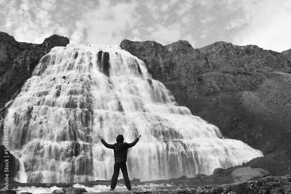 Fototapeta premium A boy alone in front of the waterfall of Iceland - Europe
