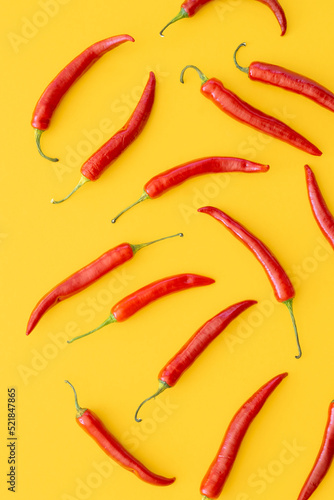 Flat lay dried red chili peppers pattern on a yellow color background. Top view, flat lay.