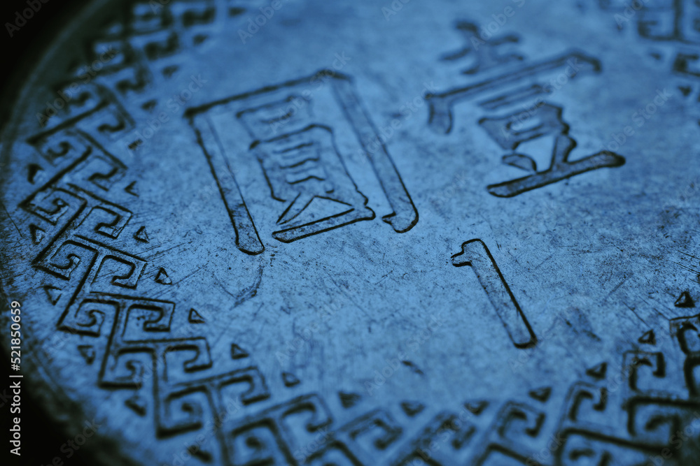 Translation: one yuan. 1 New Taiwan dollar. Fragment of textured coin. Blue tinted background or wallpaper about economics or banking. Coins and money of Taiwan. News about exchange rate or inflation Translation: one yuan. 1 New Taiwan dollar. Fragment of textured coin. Blue tinted background or wallpaper about economics or banking. Coins and money of Taiwan. News about exchange rate or inflation