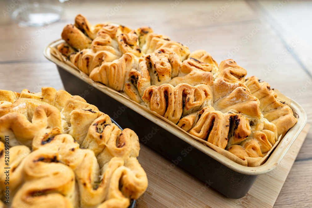 Homemade rectangular and round bread with garlic butter and herbs, in a baking tin. Homemade rectangular and round bread with garlic butter and herbs, in a baking tin.