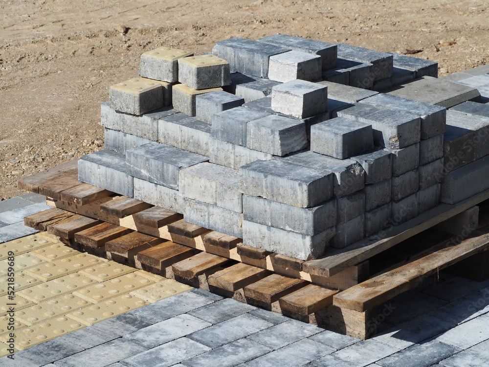 Obraz premium Paving stone laying works. Wooden pallets with paving stones. Improvement of city streets. Special paving stone for blind and visually impaired people