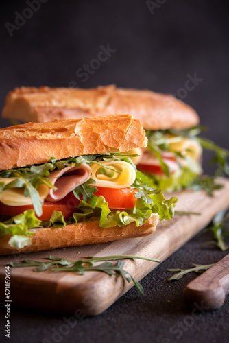 Baguette sandwich with cheese, ham, tomatoes and vegetables
