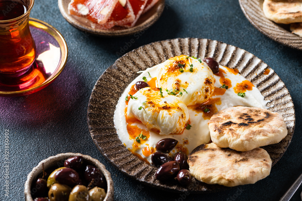 Cilbir or Turkish Eggs. mezze: poached eggs topped over herbed greek yogurt, then drizzled with hot spiced paprika olive oil. Traditional Turkish breakfast with rahat Cilbir or Turkish Eggs. mezze: poached eggs topped over herbed greek yogurt, then drizzled with hot spiced paprika olive oil. Traditional Turkish breakfast with rahat