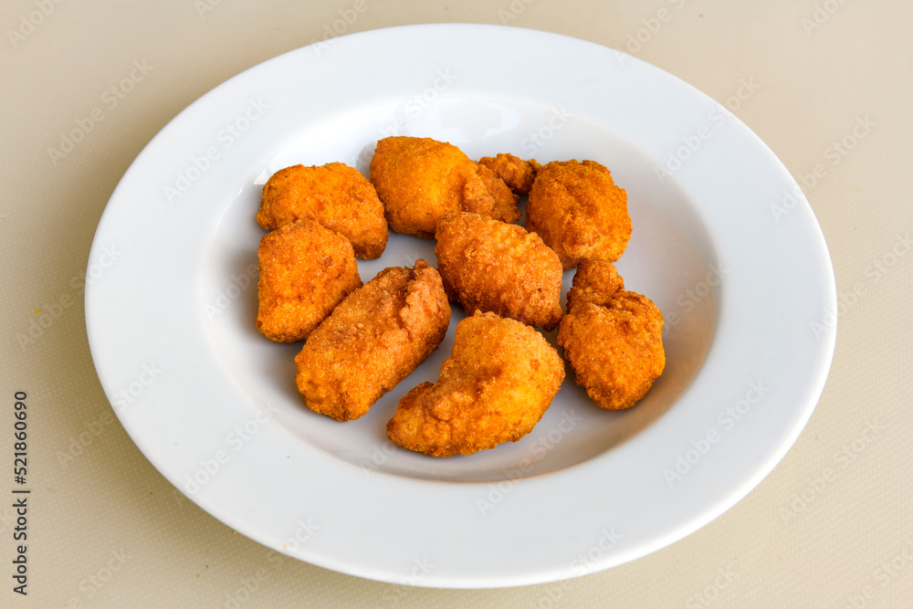 Fried Chicken breast hot crispy strips crunchy chicken tenders isolated on white background.Nuggets isolated on white background on a plate Fried Chicken breast hot crispy strips crunchy chicken tenders isolated on white background.Nuggets isolated on white background on a plate