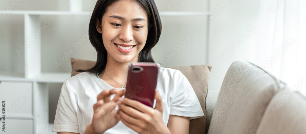 Half-Japanese woman sitting on the sofa using mobile while on vacation, Rest at home, Living room, Relax time, Touch screen tablet, Go on internet, Favorite corner, Personal space