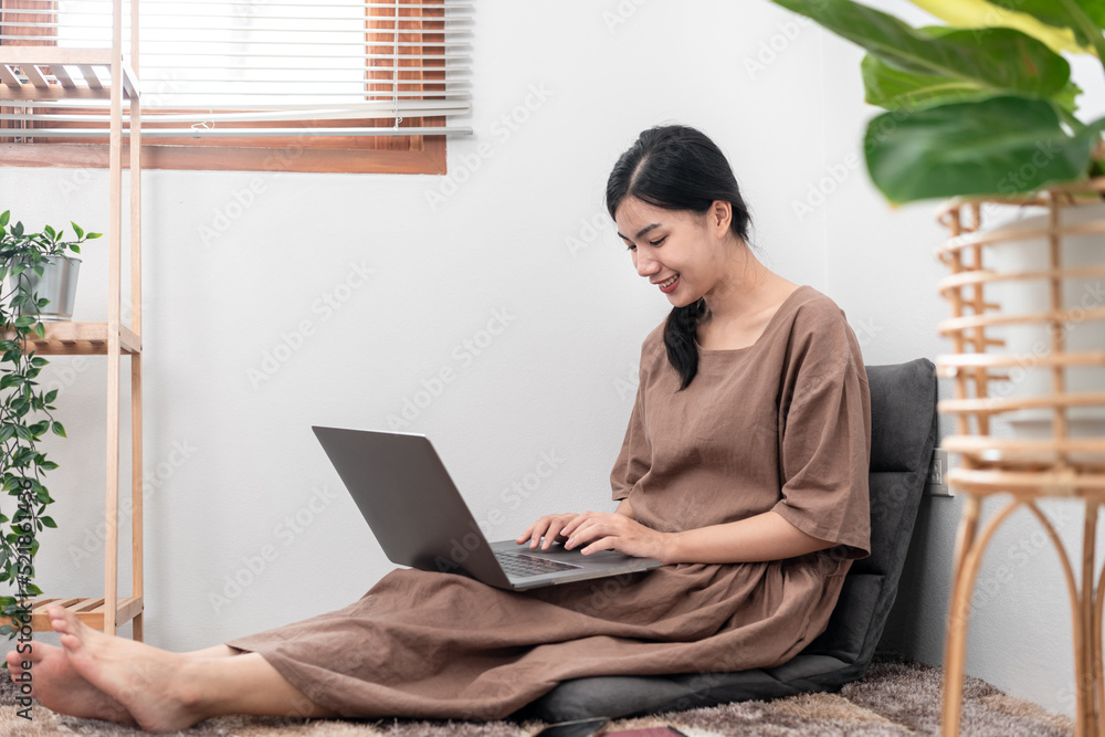 Beautiful woman is using laptop to chatting and talking with friends on video call while sitting Beautiful woman is using laptop to chatting and talking with friends on video call while sitting