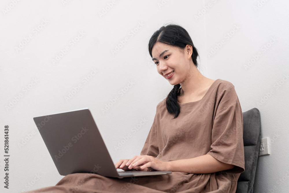 Beautiful woman is using laptop to chatting and talking with friends on video call while sitting Beautiful woman is using laptop to chatting and talking with friends on video call while sitting