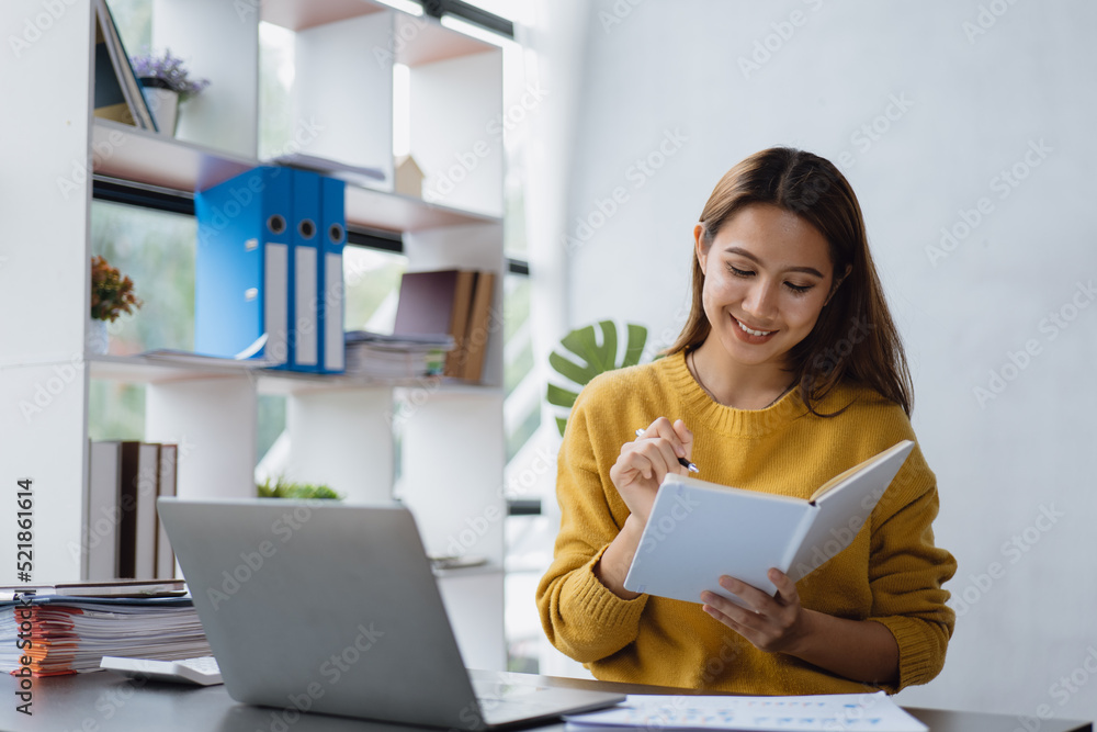 Young business woman is working and learning on paperworks and laptop in office space. Young business woman is working and learning on paperworks and laptop in office space.
