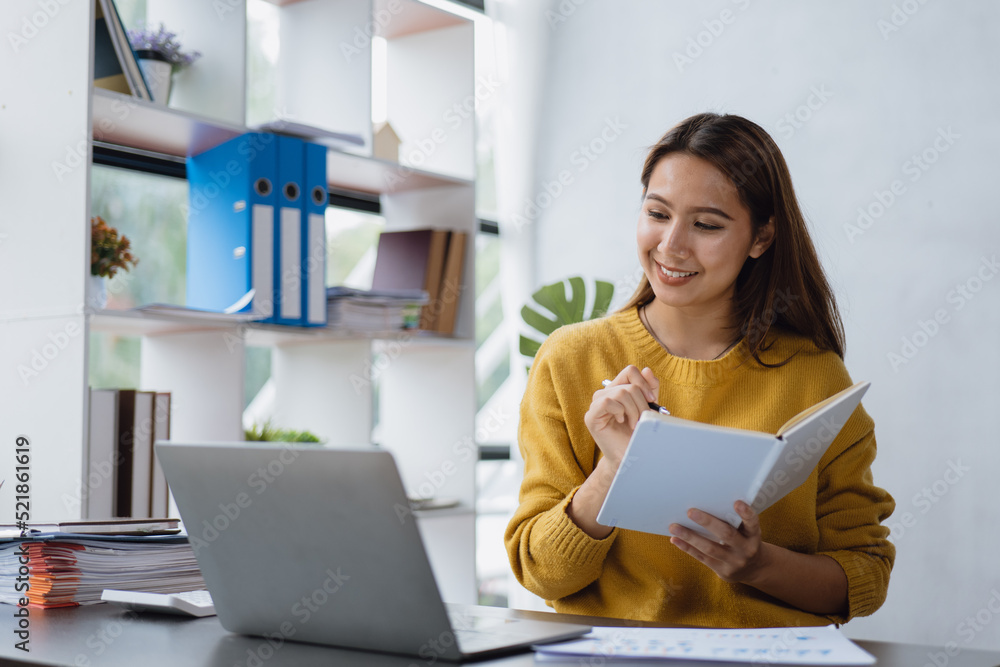 Young business woman is working and learning on paperworks and laptop in office space. Young business woman is working and learning on paperworks and laptop in office space.