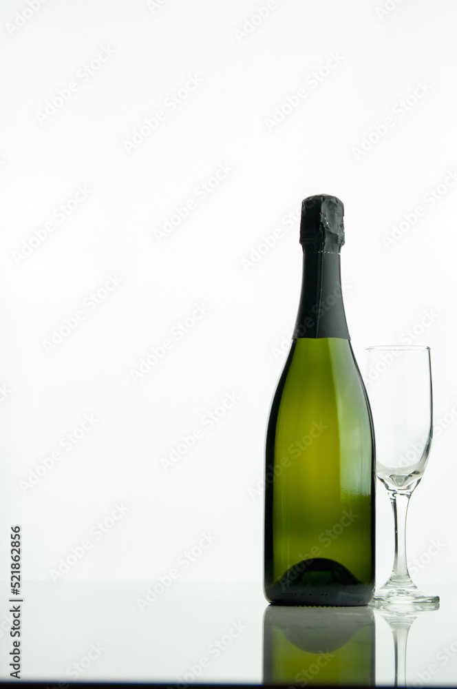 Bottle of champagne and a glass on a white background