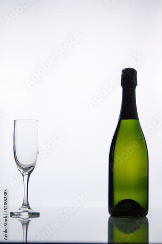 Bottle of champagne and a glass on a white background