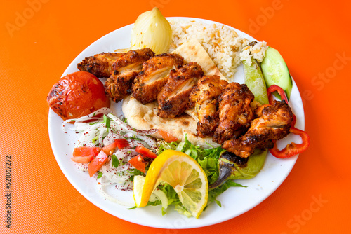 Chicken wings barbeque in a dish with BBQ sauce . Izgara tavuk sis kanat.