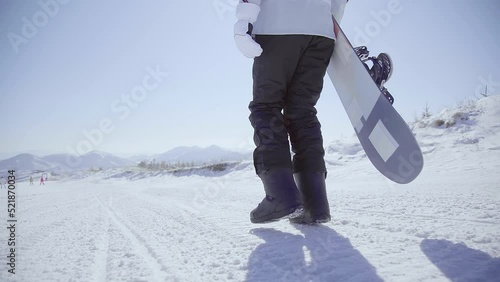 Young woman walking with snowboard on the snow,4K photo