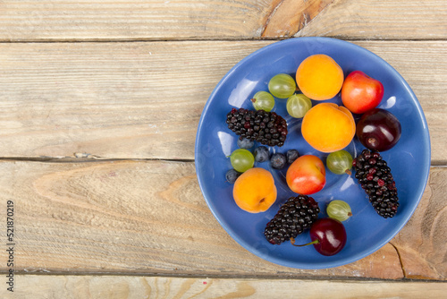 Various summer Fresh berries in a bowl on rustic wooden table. .Antioxidants, detox diet, organic fruits. Top view
