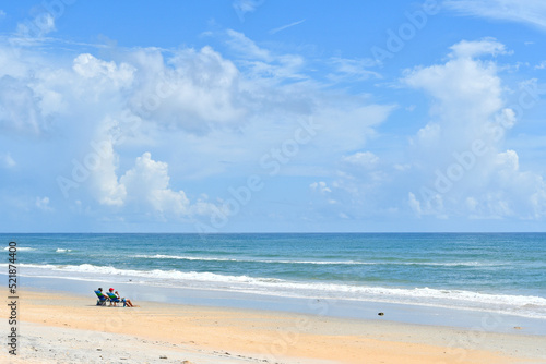 Fototapeta Naklejka Na Ścianę i Meble -  Couple enjoying a beautiful day at a quiet beach near Palm Coast, Florida between Flagler Beach and St. Augustine. 