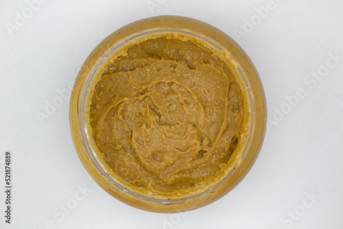 close up of a jar of peanut butter on white