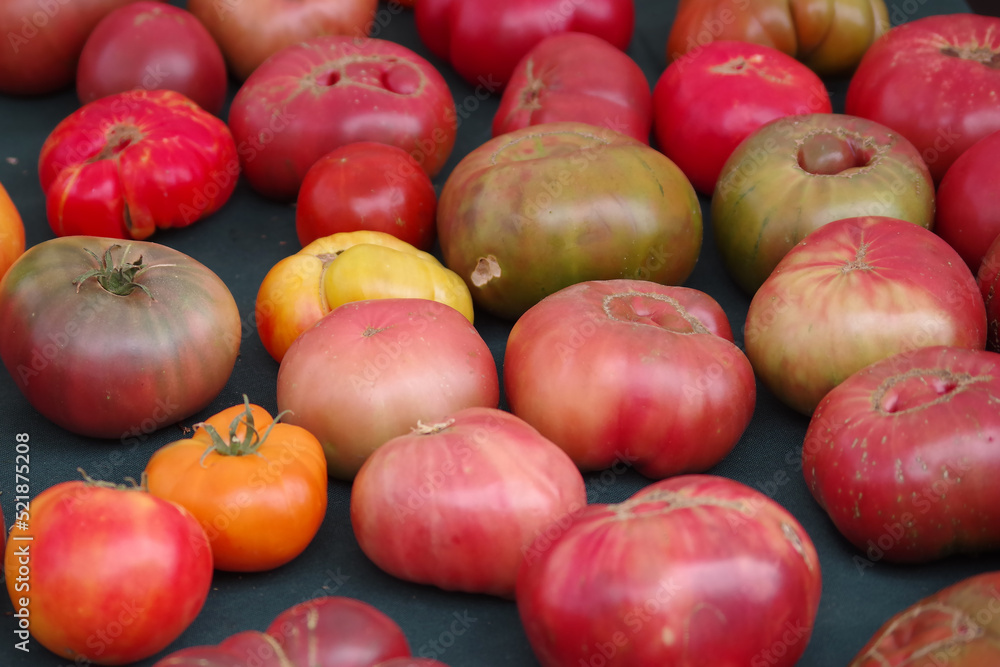 Fresh heirloom tomatoes on display at a farmers market Fresh heirloom tomatoes on display at a farmers market