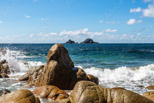 The Brisons viewed from Porth Nanven beach, on a sunny summer's day photo